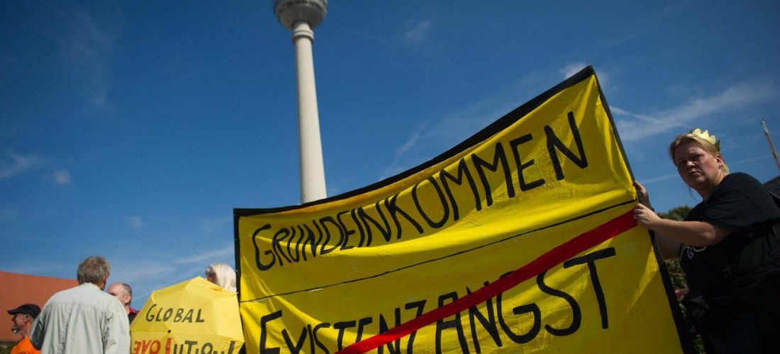 Berlin, Teilnehmer der Demonstration Grundeinkommen ist ein Menschenrecht für ein Bedingungsloses Grundeinkommen am Samstag (14.09.13) vor dem Fernsehturm mit einem Transparent mit dem Aufdruck Grundeinkommen und dem durchgestrichenen Schriftzug Existenzangst .